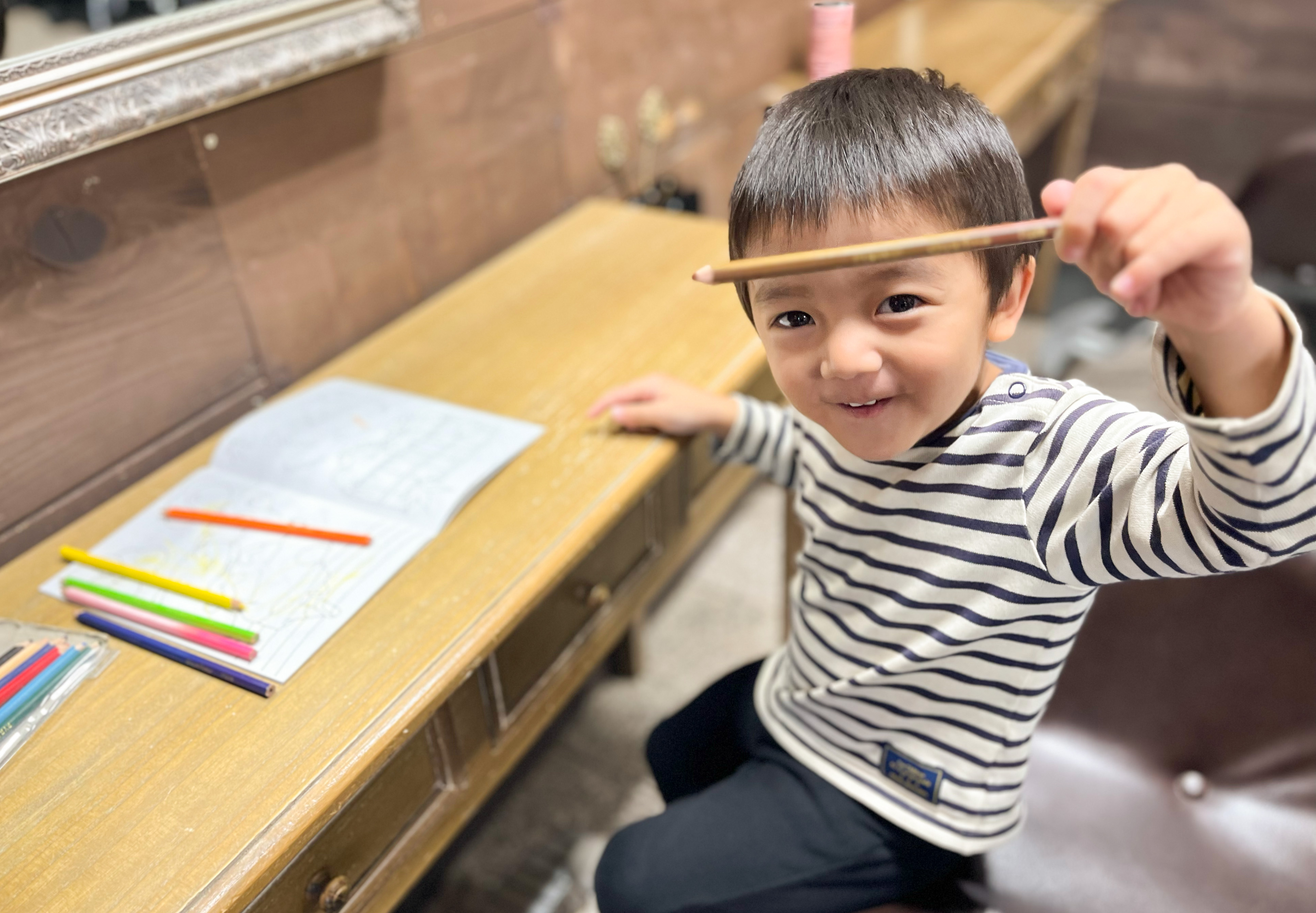 隣の席で塗り絵をしている子供の画像